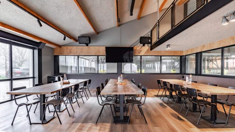 Maatwerk interieur kantine met houten tafels in combinatie met staal en beton