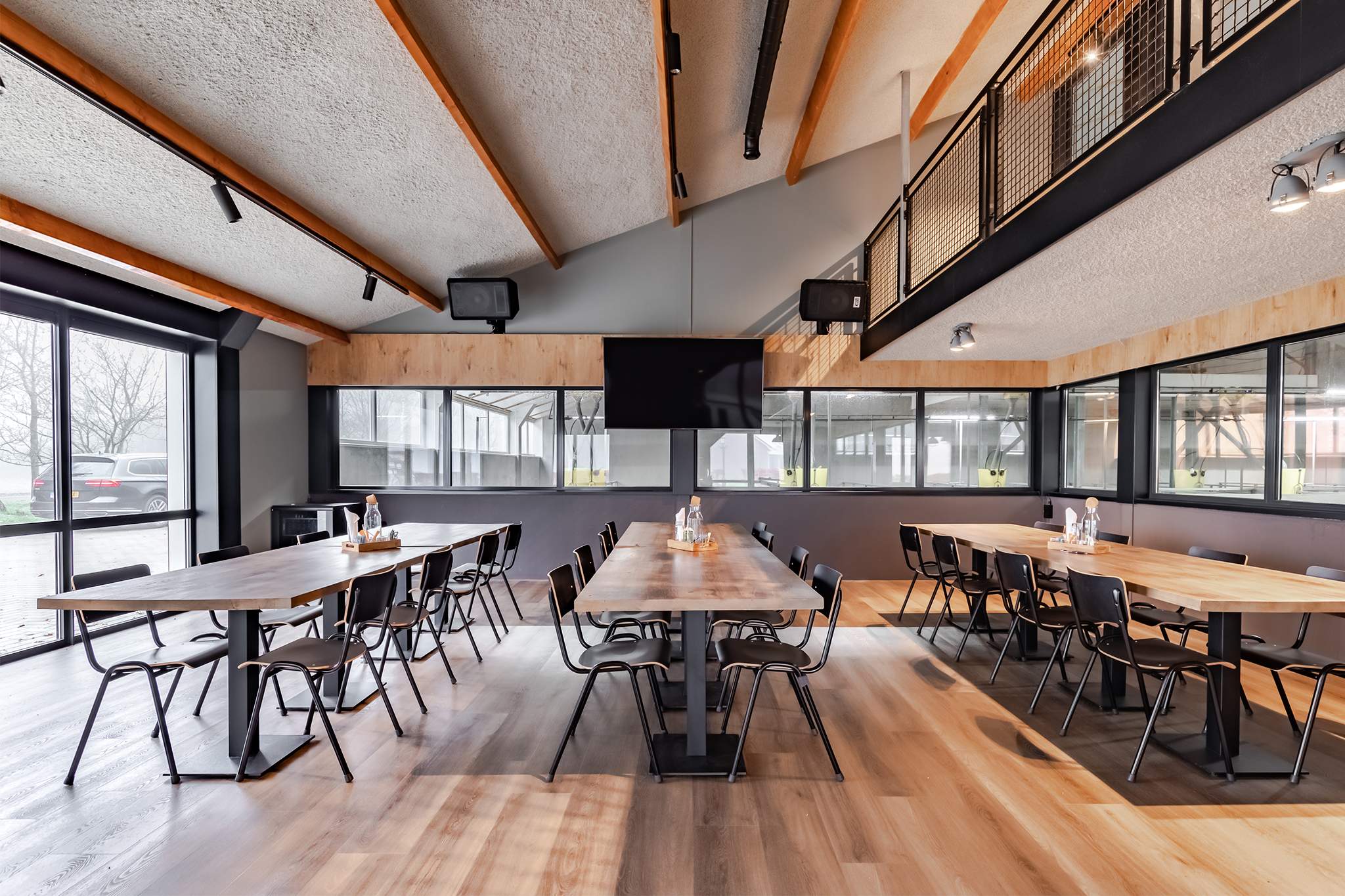 Maatwerk interieur kantine met houten tafels in combinatie met staal en beton
